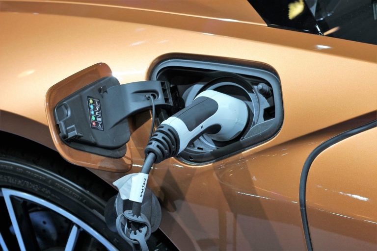 Thuislaadstation voor elektrische voertuigen in garage met oplaadkabel aangesloten op auto