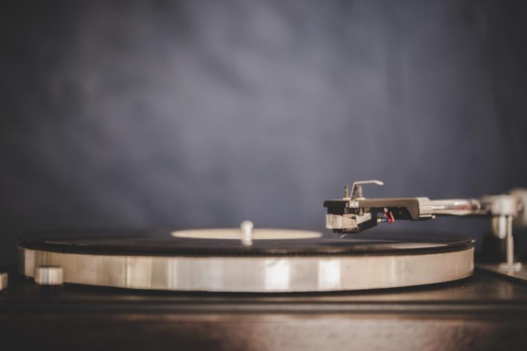 Vintage platenspeler draaiend met vinyl plaat in klassiek houten ontwerp met glanzende metalen componenten