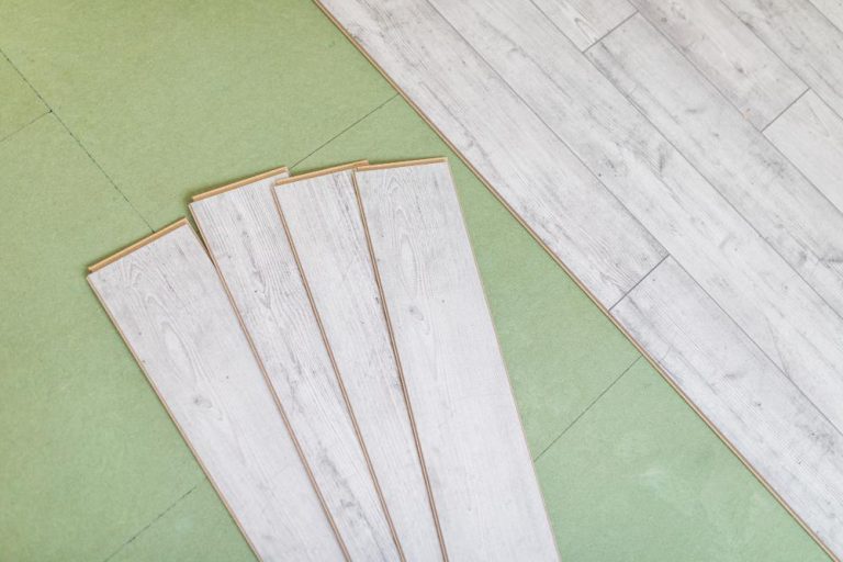 Grijze laminaat vloerplanken met glanswerking - voorbeeld van stijlvolle PVC vloeren ontwerp