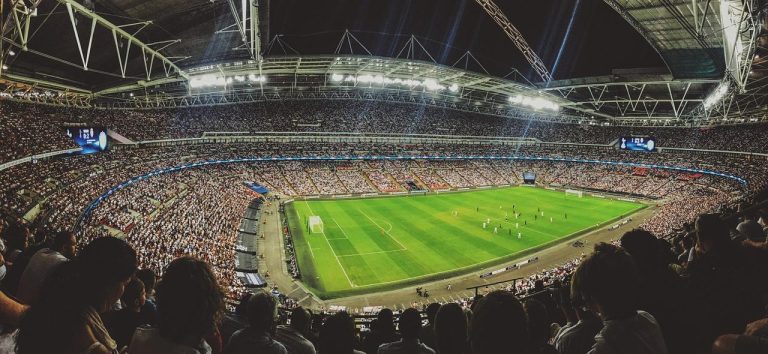Fans in stadion tijdens voetbalreizen ervaren de live sfeer van een spannende wedstrijd